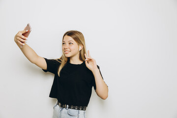 A teenage girl is using a cell phone against grey background