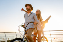 Young Attractive Man And Woman Traveling On Bicycles, Holding Map, Sightseeing, Romantic Couple On Summer Vacation By The Sea On Sunset, Boho Hipster Style Outfit, Friends Having Fun Together