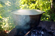 Old cast iron cooking pot  on the fire. Cooking composition of the old cooking. 