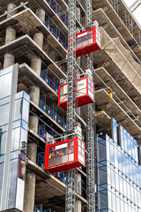 Elevators lift workers to the construction sites of a skyscraper under construction
