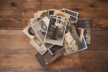 Old Vintage Monochrome Photographs In Sepia Color Are Scattered On A Wooden Table, The Concept Of Genealogy, The Memory Of Ancestors, Family Ties, Memories Of Childhood