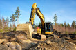 Yellow excavator building a road deep in the forest. Rusko, Finland.