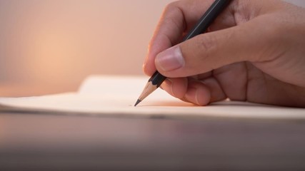 Poster - Close-up of hand writing on a notebook with pencil