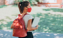 Back To School University Student Girl Wearing Covid Mask Walking On Campus With Backpack, Books And Laptop. Corona Virus Lifestyle.