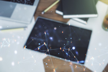 Poster - Creative abstract wireless technology hologram and modern digital tablet on desktop on background, top view, artificial intelligence and machine learning concept. Multi exposure
