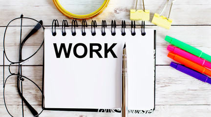 Poster - WORK written in a notebook on white background with office tools