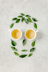 Wall Mural - Two cup of fresh green tea with tea leaves. Flat lay, top view. Tea concept