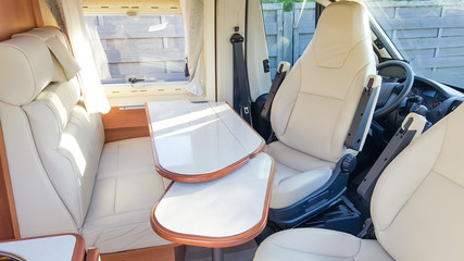vacation campervan with luxury white interior table wooden and seat in modern motor home during vanlife concept