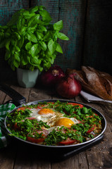 Excellent breakfast (lunch) - shakshuka. Fried eggs with vegetables in a frying pan.