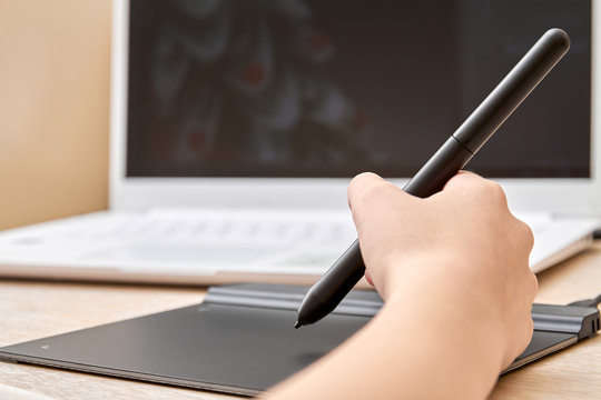 Girl draws on a graphics tablet with pen. Close-up, selective focus