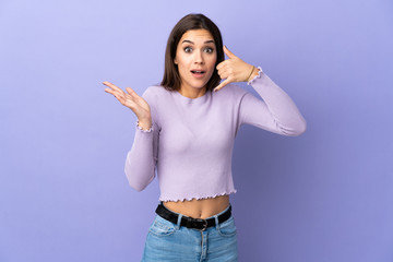 Young caucasian woman over isolated background making phone gesture and doubting