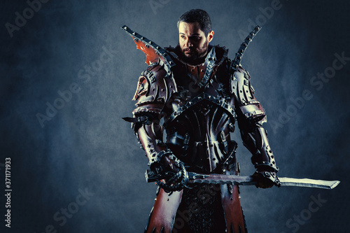 Fotomural Powerful knight in the armor with the sword. Dark background.