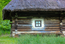 A Wooden House In The Forest. An Old Dilapidated Hut With An Old Straw Roof. Cozy Place To Relax In The Bosom Of Nature In Summer. Ukrainian Carpathians.