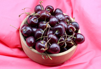 Wall Mural - red cherries on a colorful fabric background