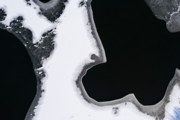 Canvas Print - Flying above ice, top down aerial view of ice floes in the lake.