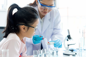 Wall Mural - asian children analyzing study evaluating microscope with scientist. health care researchers doing s