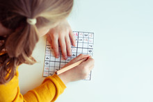 Teen Girl Solving Sudoku At Desk At School Or At Home. View From Above