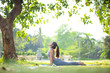 © Near - Young asian woman doing yoga under the tree in park