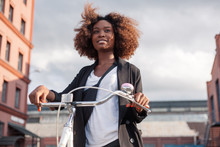 Pretty Young Black African American Woman Riding Bicycle On The Street Smiling Portrait.