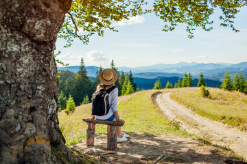 Trip to Carpathian mountains. Woman tourist hiking and relaxing admiring landscape. Traveling in summer Ukraine