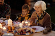 © Clique Images/Stocksy - Granny Telling Stories At Festive Dinner