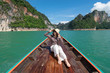 Young Asian women traveler enjoy fun relaxing and sitting on long tail boat at Cheow Lan lake, Ratchaprapha Dam, Khao Sok National Park, Ban Ta Khun District, Surat Thani Province, Thailand