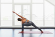 © MyMicrostock/Stocksy - Back view of beautiful young woman doing yoga postures in luxury apartment