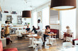 © Bonninstudio/Stocksy - Waitress and clients in cozy cafe
