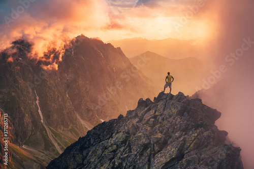 Cuadros en Lienzo Man in mountains, silhouette of young hiker, sunset sky and hills in background Travel, adventure or expedition concept