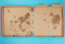 Above View Of Greasy Empty Delivery Pizza Box On Blue Background