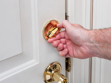 Man Locking Deadbolt Door Lock On White Entry Door. Home Security Burglar And Robbery Prevention.