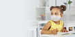 © ShunTerra - A dark-skinned girl in a medical mask and yellow dress in the school after covid