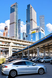 Fototapeta  - freeway intersection in modern city landscape against downtown skyscrapers skyline background Street view of urban highway transportation infrastructure in Moscow city Russia Vertical photo