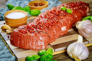 Wall Mural - Raw beef steak on a cutting board with basil and spices.