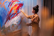© DC Studio - Happy fine artist painting on large canvas in art workshop. Modern artwork paint on canvas, creative, contemporary and successful fine art artist drawing masterpiece