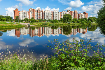 Saint Petersburg, Russia, June 13, 2020.  Multi-storey modern residential buildings and reflection in the pond