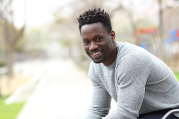 Wall Mural - Happy black man posing looking at camera on a park