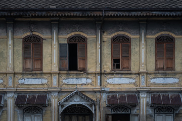 Wall Mural - Beautiful ancient wooden stencil engraving windows and stucco pattern with and old yellow historical building exterior architecture