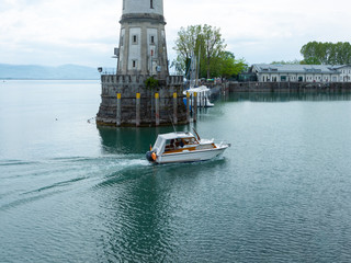 Lindau, Germany - May 2 2019: Small boat entering the harbor of Lindau (Germany)