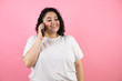 © Irene - Young beautiful woman talking on the phone, smiling on pink background.