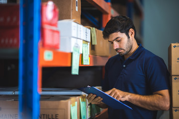 Male warehouse worker working for check and analyze newly arrived goods for further placement in storage department. Employee organizing goods distribution to the market