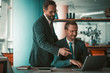 © Svyatoslav Lypynskyy - Businessmen teamwork with laptop. Two Caucasian people planning strategy of development project on computer in modern office. Tinted image.