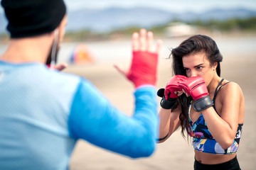 Wall Mural - Woman training kickbox with a coach; Active lifestyle concept