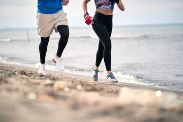 Wall Mural - Male and female running on the beach; Healthy lifestyle concept