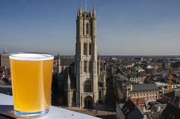 Sticker - Glass of light Belgian beer against view of big cathedral in Ghent, Belgium