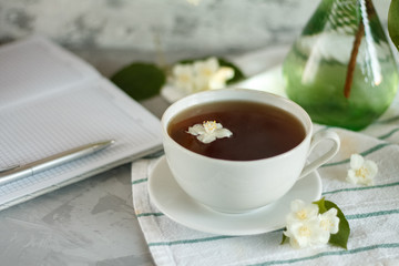 a Cup of tea and Jasmine flowers on the table on a spring morning