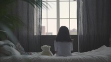 A Little Sick Girl Sits On The Bed And Hugs A Soft Toy; Drip Near