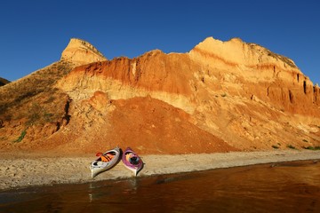 Picturesque sunset landscape of Stanislav mountains and the Black sea beach with two baidarka or kayak boats, Ukraine