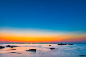 Wall Mural - Sunset sea with rocks and sunset night landscape on dramatic sky under moon light