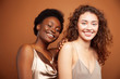 © iordani - two pretty girls african and caucasian blond posing cheerful together on brown background, ethnicity diverse lifestyle people concept